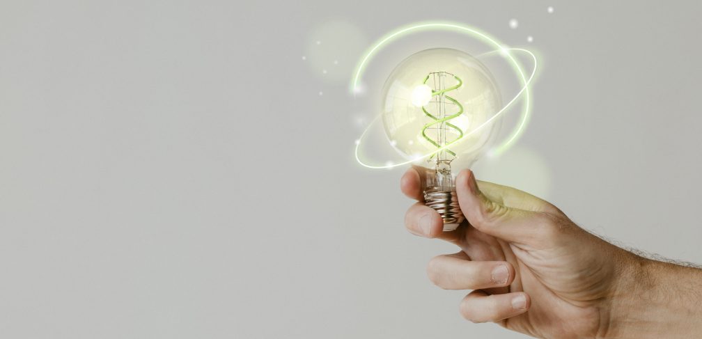 Green energy with hand holding an environmental light bulb background