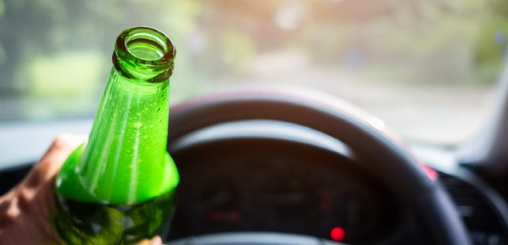 man-holding-drinking-beer-while-driving-car_73622-1721